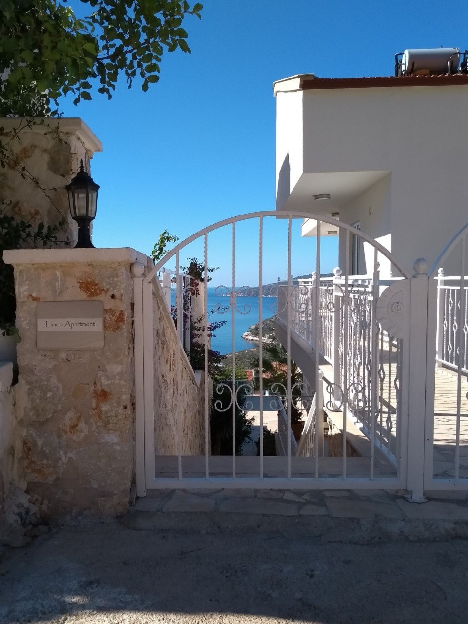 Gate entrance to Kalkan Limon Apartment with decorative metalwork and sea views.