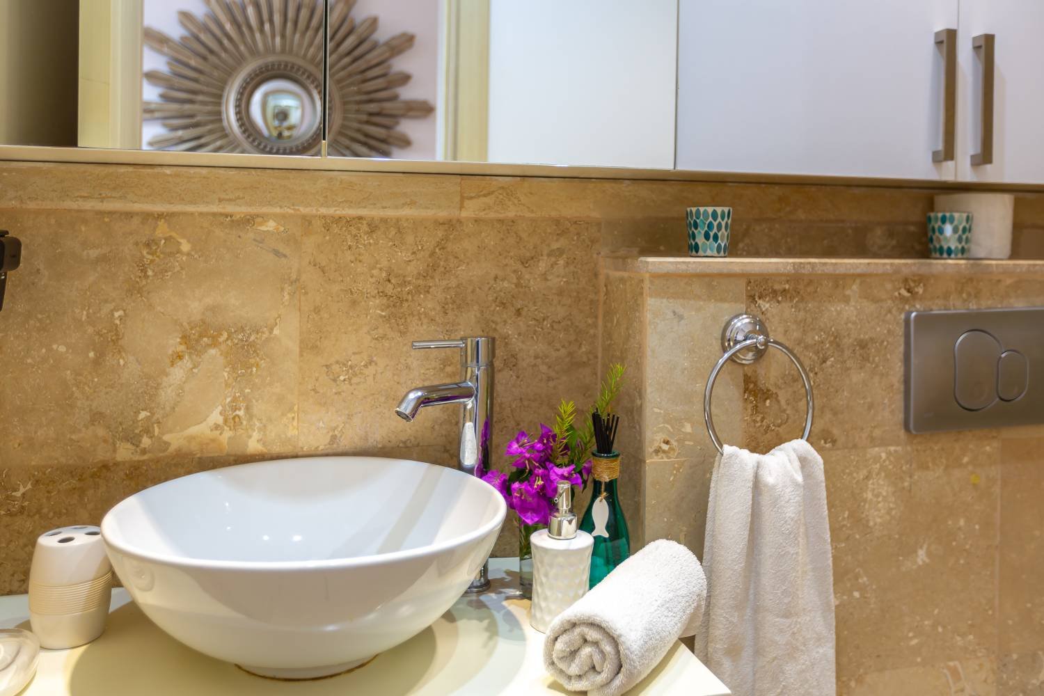 Bathroom sink area at Kalkan Limon Apartment with marble tiles, vessel basin and decorative accessories.