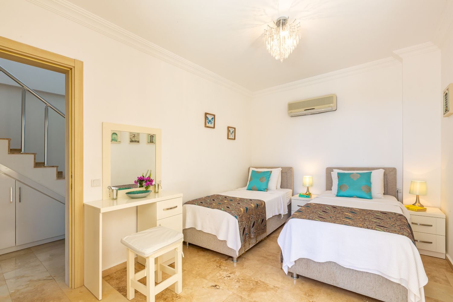 Twin bedroom at Kalkan Limon Apartment with two single beds, teal accents and modern décor.