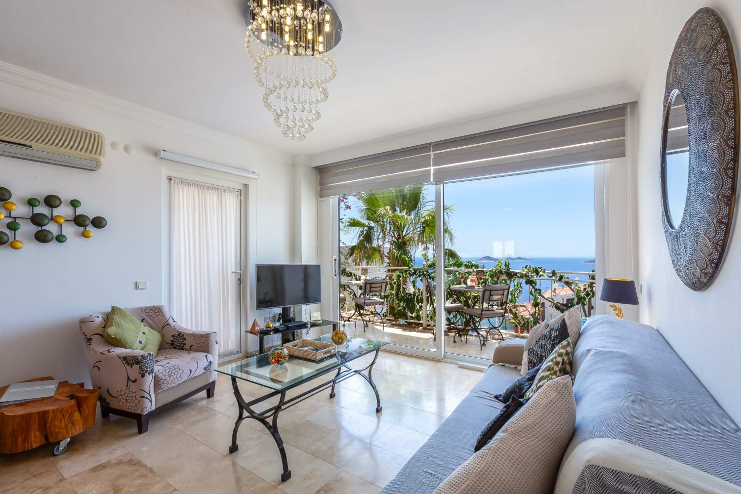 Lounge area at Kalkan Limon Apartment with TV, modern seating and balcony sea views.