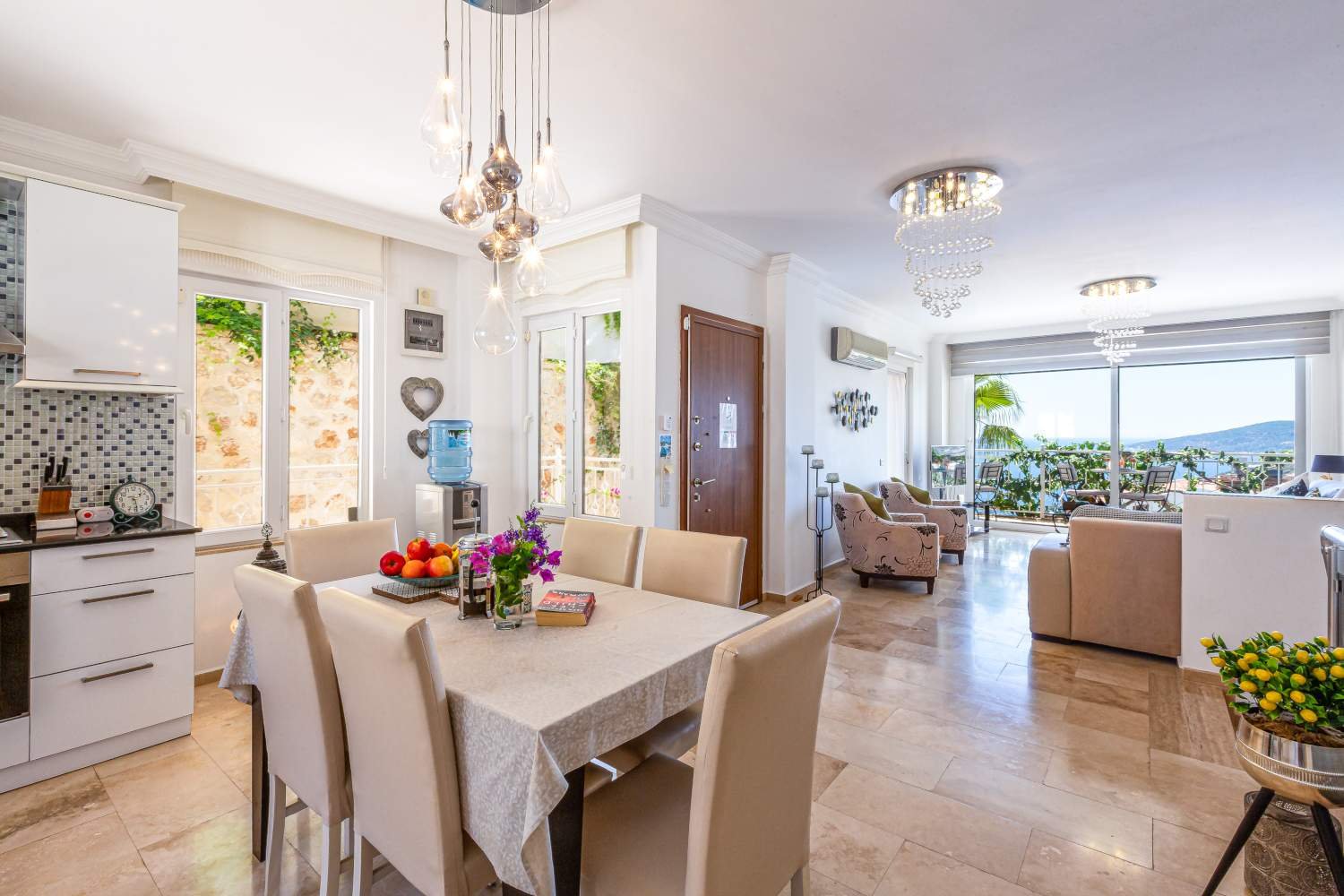 Open‑plan kitchen, dining and living area at Kalkan Limon Apartment with modern décor and sea‑view balcony.