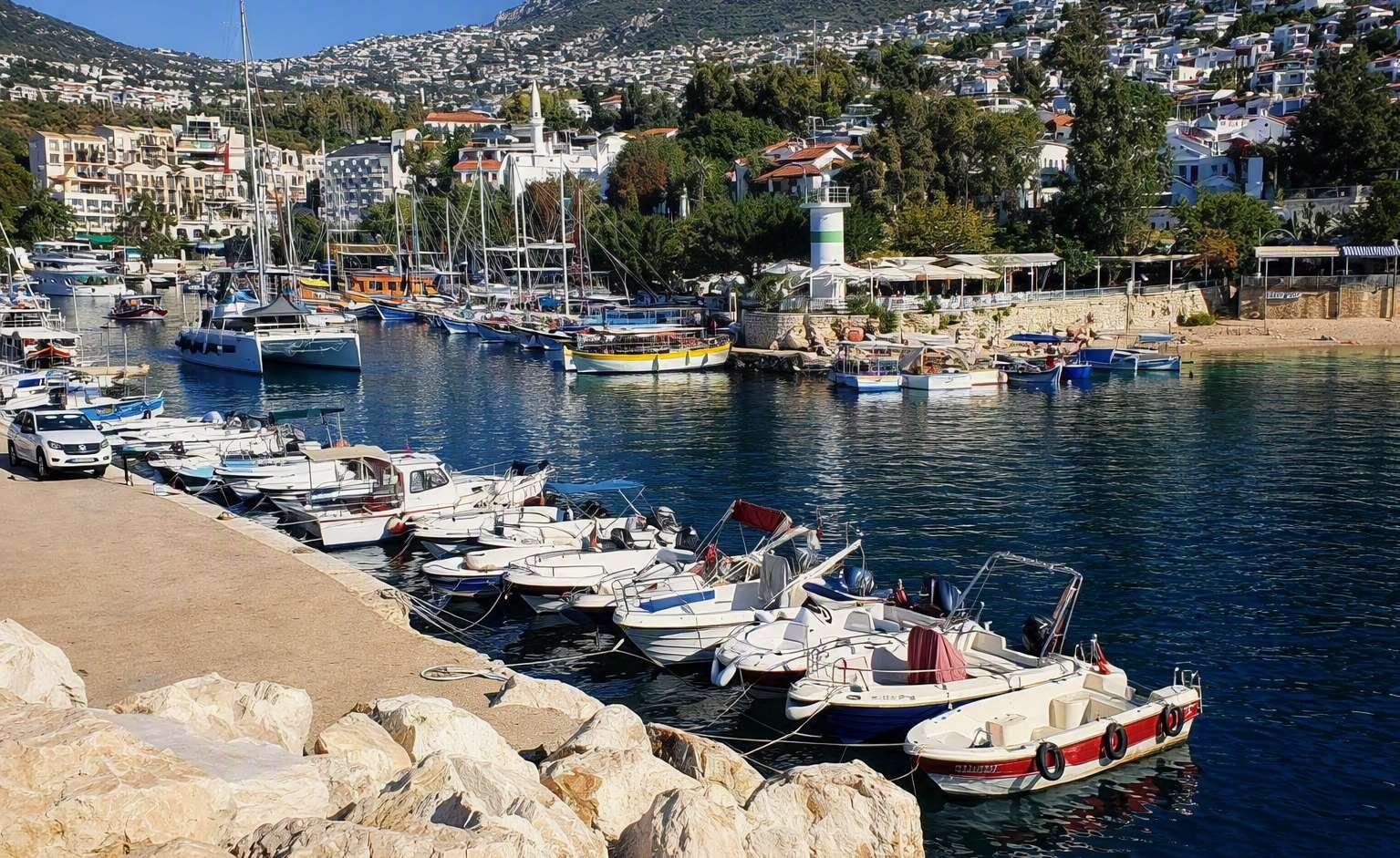 Marina with boats, calm water and hillside buildings near Kalkan.