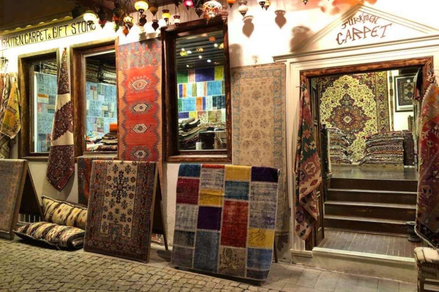 Turkmen Carpet & Gift Store in Kalkan with colourful handmade rugs displayed outside the shop.