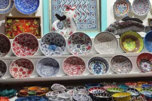 Hand‑painted Turkish ceramic bowls and plates displayed on shelves in a Kalkan pottery shop.