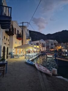 Meis harbour at dusk with waterfront restaurants, boats and calm reflective water near Kalkan.