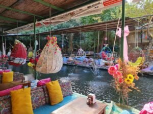 Colourful riverside seating area at Saklıkent with hanging wicker chairs, fountains and vibrant décor.